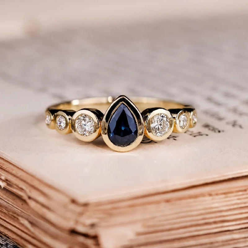 Engagement rings with trillion-cut moonstone gems -The Lyra - Bezel Set Pear Cut Blue Sapphire Engagement Ring with Diamond Accents